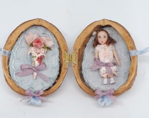 Walnut with tiny girl doll Little doll and paper cone with roses in hinged walnut shell